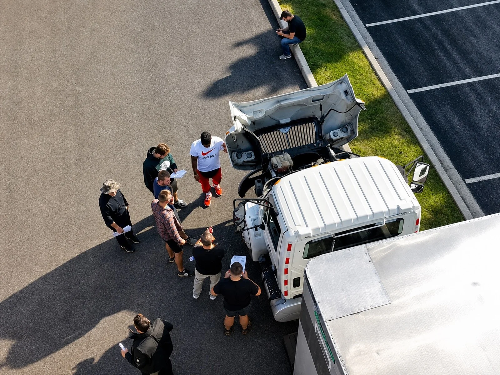 All-In CDL instructor briefing a group of students during a pre-trip inspection at the training yard